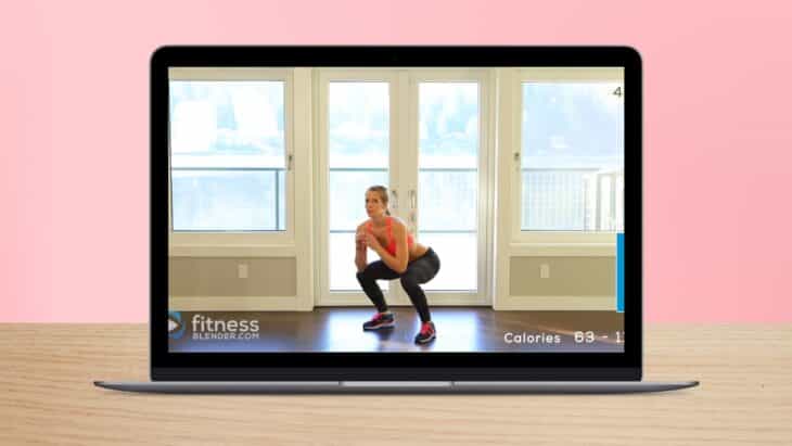 A Fitness Instructor Demonstrates a Squat Exercise in An Online Workout Video on A Laptop Screen