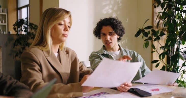 A business meeting where a young man explains a document to a woman who is an angel investor