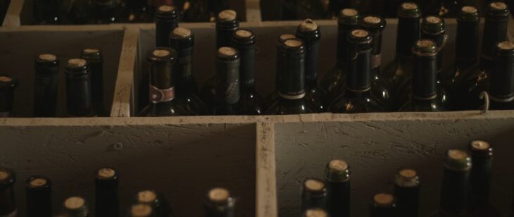Collection of rare vintage wine bottles stored in a wooden cellar rack