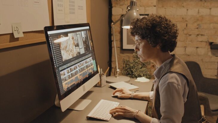 Creative professional editing high-quality images and video content on a desktop computer in a modern workspace