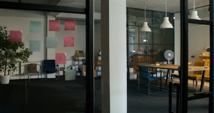 Empty startup office with post-it notes on glass, prepared for renting-based coworking setups