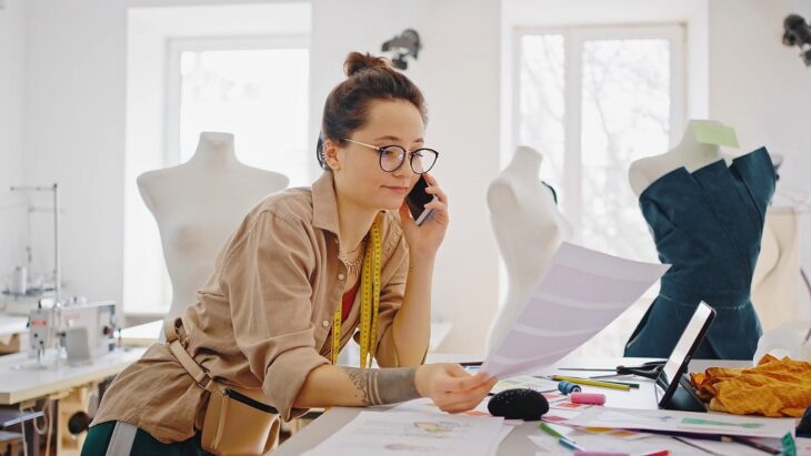 Fashion designer managing orders while on the phone