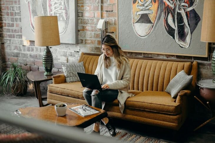 Woman working remotely on a Revenue Share Program from a cozy modern lounge