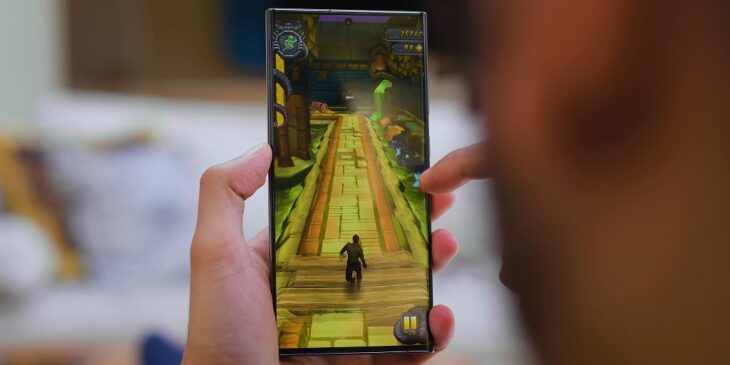 Close-up of a person playing an endless-runner mobile game on a smartphone