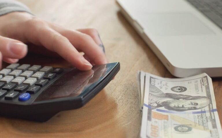 Man counts his savings on calculator