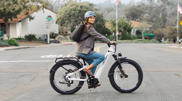 Woman on an electric bike stopped at a street crossing, ready to commute sustainably
