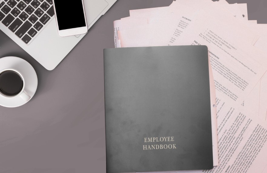 Gray employee handbook on a desk