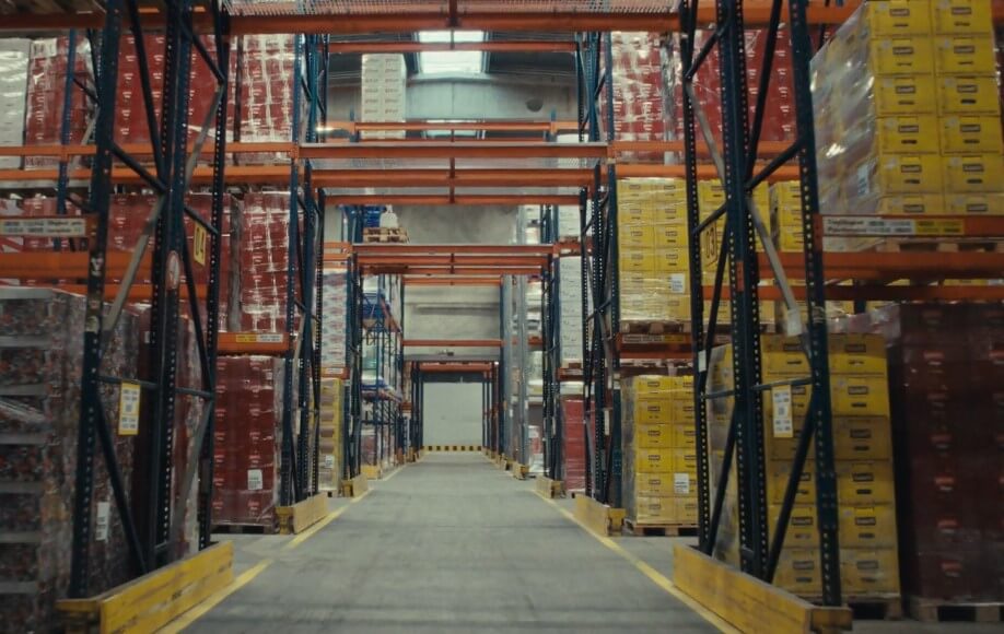 A spacious warehouse filled with numerous boxes stacked on shelves, indicating a busy storage environment