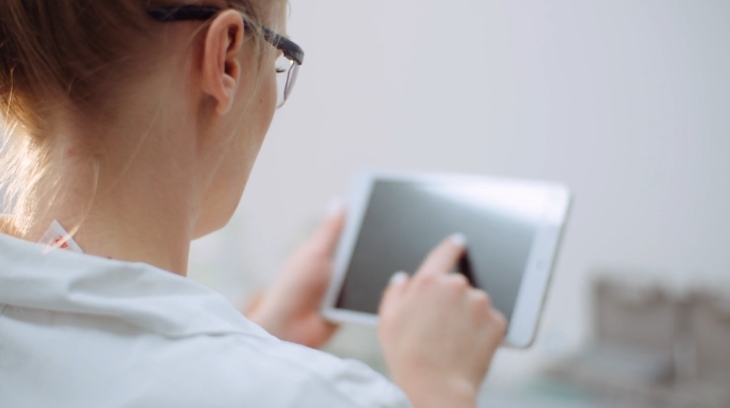Healthcare staff member reviewing core business strategy data on a tablet