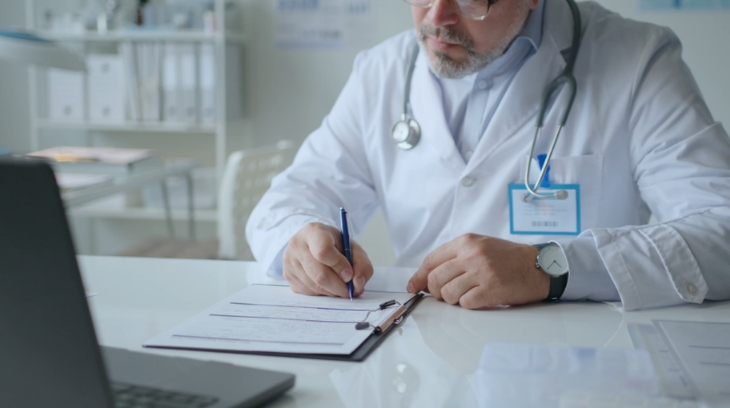 Healthcare executive reviewing strategy documents at a desk during planning work