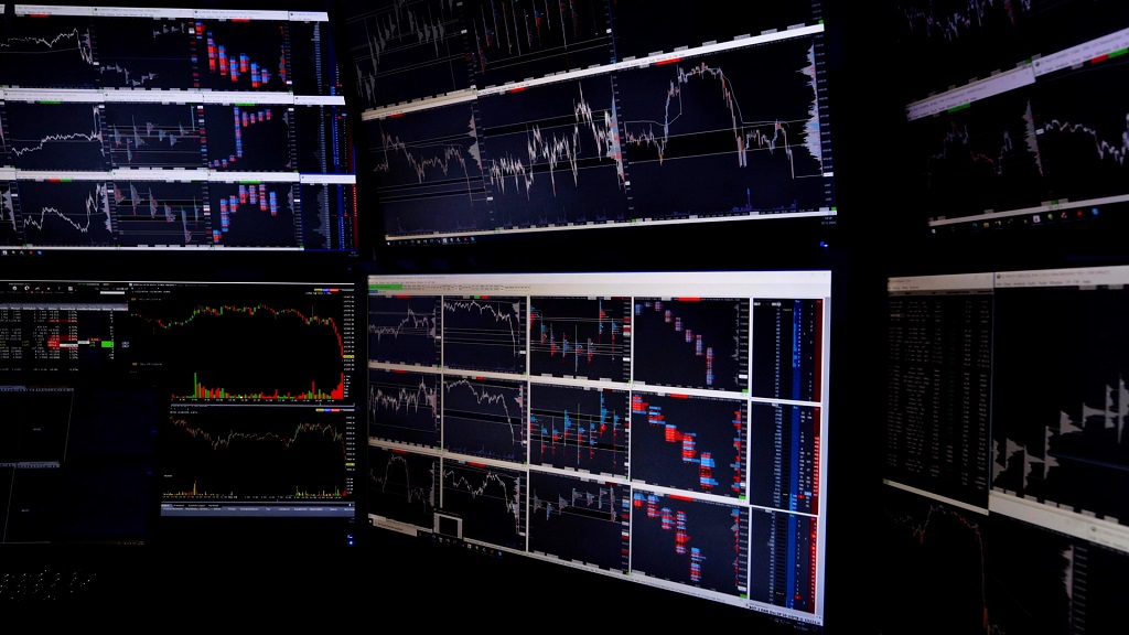 Multiple trading monitors displaying financial charts and market data used for real time market analysis
