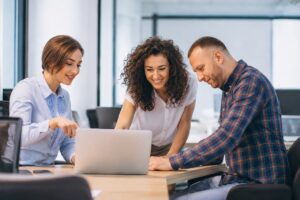 Business team discussing an Agentforce implementation project around a laptop